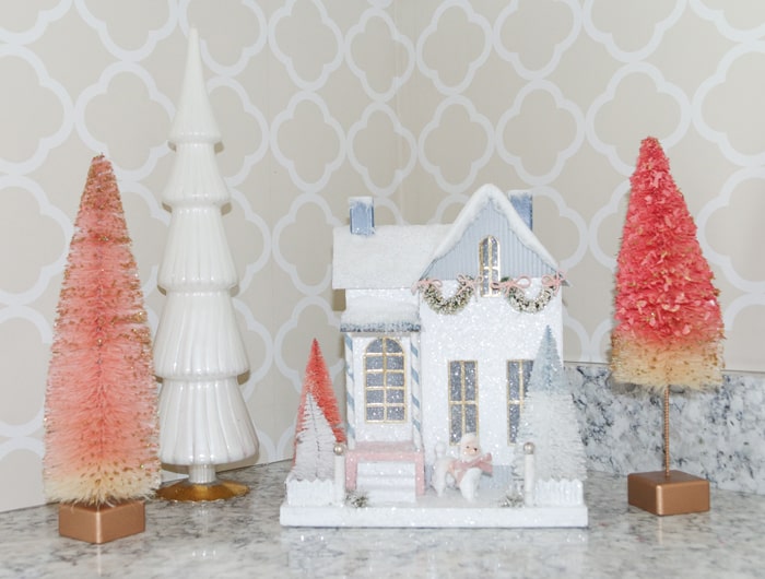 White Cody Foster glitter house with pink bottlebrush trees. Schumacher Morroco wallpaper in the background.