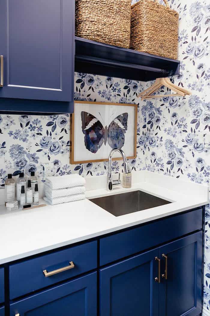 bold blue laundry room cabinets with blue floral Caitlin Wilson wallpaper