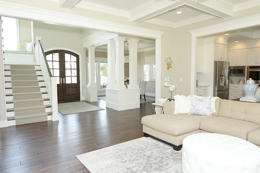 open layout of neutral home with lots of trim work and wood floors
