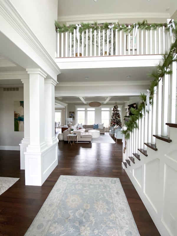 open foyer with dramatic stairs decorated with Christmas garland