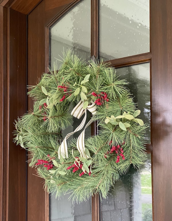 faux wreath hearth and hand target with red berries and striped grograin ribbon on wood front door window